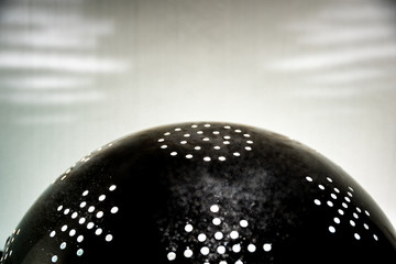 The sun in a colander. Rays of light through the holes