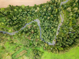 drone image. aerial view of rural area with fields and forests with snake river in woods