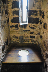 Old stone toilet in Tower of London with wooden floor. Medieval latrine in the Tower of London.