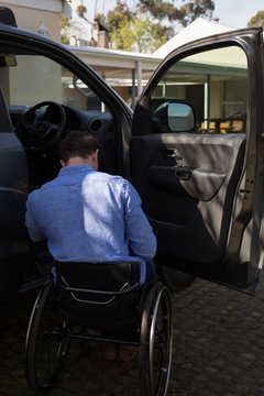 Disabled man in wheelchair near car