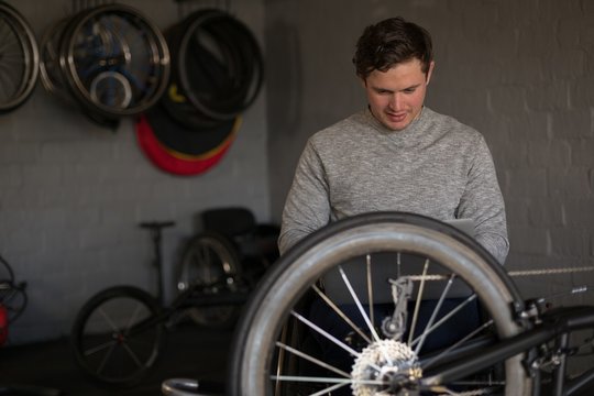 Disabled man repairing wheelchair at workshop