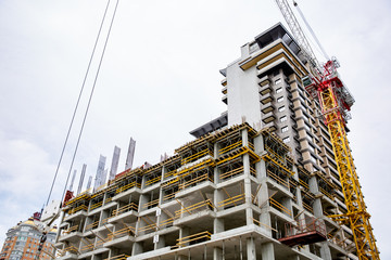 inside building sites under construction and cranes with blue sky background. unfinished cement building at construction site.