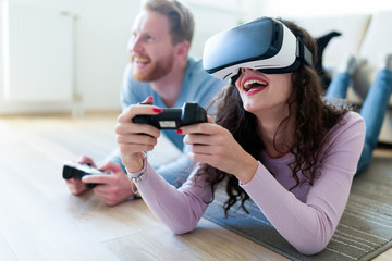 Young couple playing games with virtual reality headset