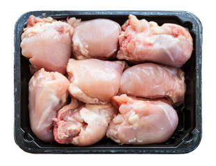 pieces of raw chicken meat on plastic tray