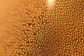 Water condensation drops on the outside of an icy cold glass of beer