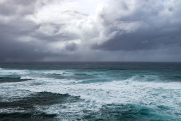 Dark storm clouds above rough waves in ominous seascape in the open ocean