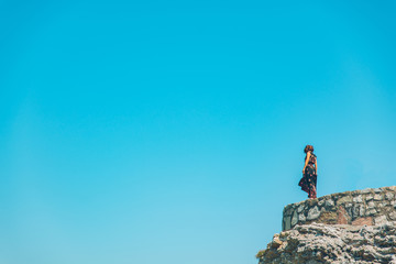 Fototapeta premium woman stand on the cliff in light dress at sunny day