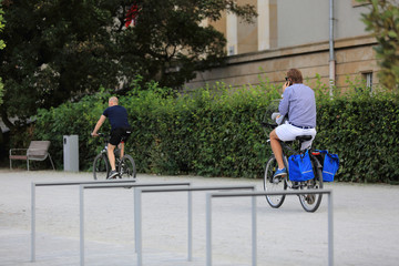 Mężczyzna jedzie na rowerze i rozmawia przez telefon.