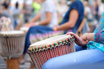 Hands of a musician playing on an African djembe drum, at a percussion music festival