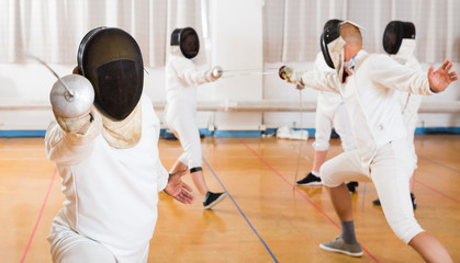 Portrait of fencer practicing lunge with foil