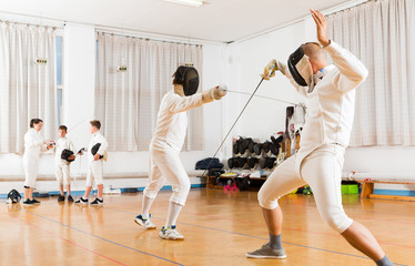 fencing  duel  of two l athletes in gym