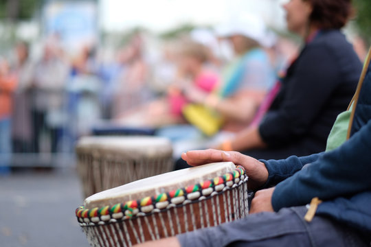 Hands of a musician playing on an African djembe drum, at a percussion music festival
