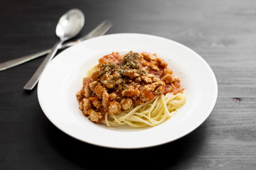 Spaghetti on black wooden background