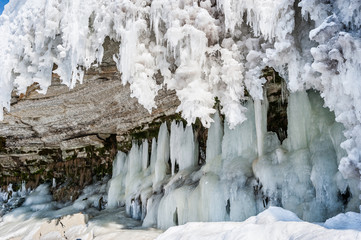 Naklejka na ściany i meble Icicles create a beautiful wall of ice over a rock ledge in Jagala Waterfall, Estonia.