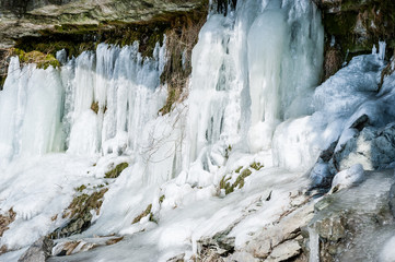 Fototapeta na wymiar Icicles create a beautiful wall of ice over a rock ledge. Jagala Waterfall, Estonia. Close- up.