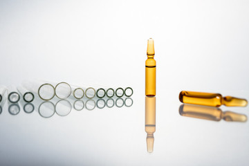 Group of vials with medication on blue methacrylate table.