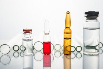 Group of vials with medication on blue methacrylate table.