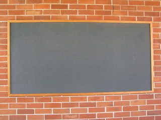 Blackboard on red brick wall in a school