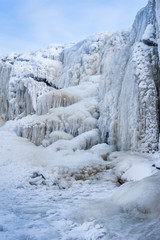 Fototapeta na wymiar Frozen cascade of waterfall. Winter background. Jagala Waterfall, Estonia. Soft focus.