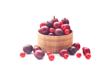 Different berries in wooden utensils on a white background