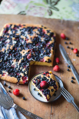 Berry assorted pie on wooden background, top view
