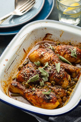 Baked chicken legs with peas, beans and fresh herbs. Chicken drumsticks with tasty sause and greens