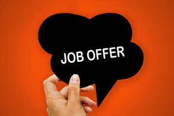 Hand holding black paper speech bubble with JOB OFFER concept, over orange background, isolated.