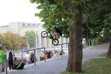 Fototapeta Młody mężczyzna skacze na rowerze przez barierkę na Wrocławskim bulwarze. obraz