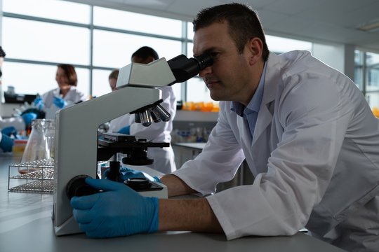 Male scientist using microscope