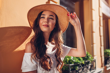 Outdoor portrait of young beautiful woman with long hair wearing straw hat. Fashion model. Close-up