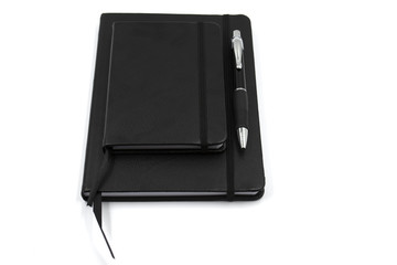 Conjunto de libreta, bolígrafo, móvil y grapadora de color negro en fondo blanco. Oficina