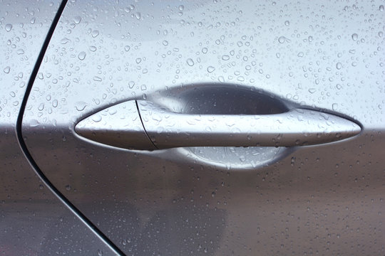 Closeup of a wet car door handle. Car wash concept background.