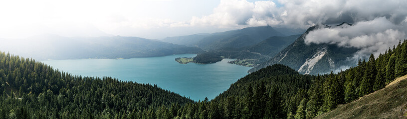 Obraz premium Mountain panorama with lake and forest and clouds