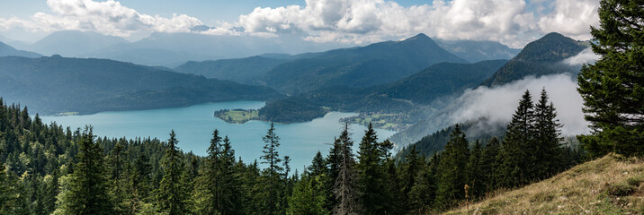 Mountain panorama with lake and forest and clouds