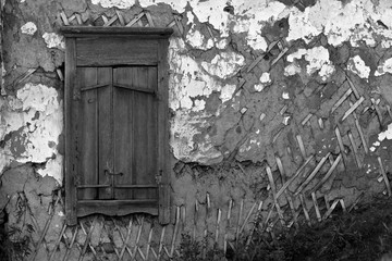 Fragment of a dilapidated wall with a window in black and white tones