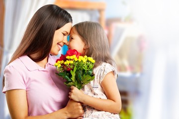 Portrait of happy mother and daughter holding  flowers