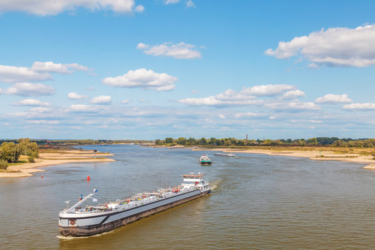 The Dutch Waal river near Nijmegen with cargo ships passing by