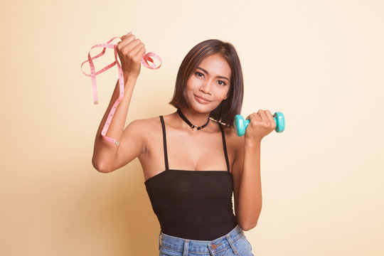 Healthy Asian woman with dumbbells and measuring tape. © halfbottle
