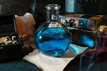 Magic concept. Blue Potion in bottle and wooden box