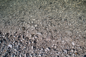The texture of white river stones. The river of Slovenia with blue water