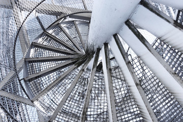 swirling metal staircase leading down, descending the stairs to the bottom