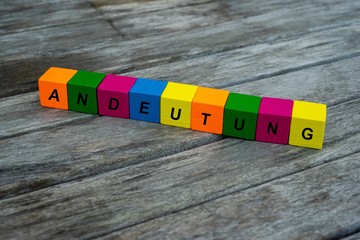 Farbige Holzwürfel mit Buchstaben auf dem das Wort Andeutung abgebildet ist, Abstrakte Illustration