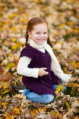 Happy Little Girl in Autumn Leaves