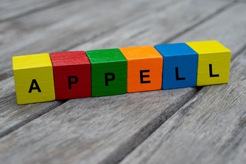 Farbige Holzwürfel mit Buchstaben auf dem das Wort Appell abgebildet ist, Abstrakte Illustration