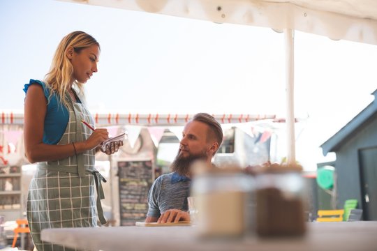 Female Waitress Taking Order In Outdoor Cafe