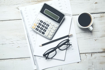 Calculator and glasses on documents on table