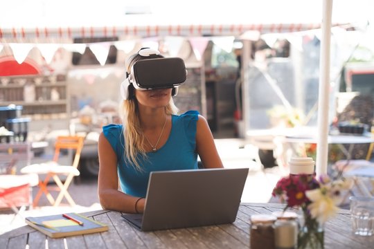 Woman using virtual reality headset with laptop