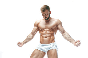 bodybuilder posing. Beautiful sporty guy male power. Fitness muscled manin white lingerie. on...