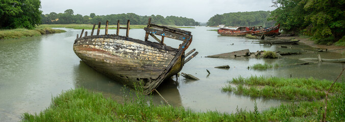 Panorama sur des épaves de bateaux dans un cimetière marin dans le bras d'une rivière sous la...