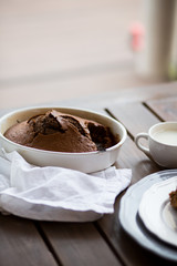 chocolate cake with cream and cup of milk on wood table